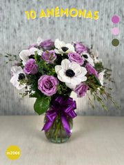 Arreglo Floral de Anémonas y Rosas Lila con Follaje Parvifolia en Florero de Vidrio Regis