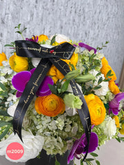 Arreglo con ranunculus amarillos y orquídeas